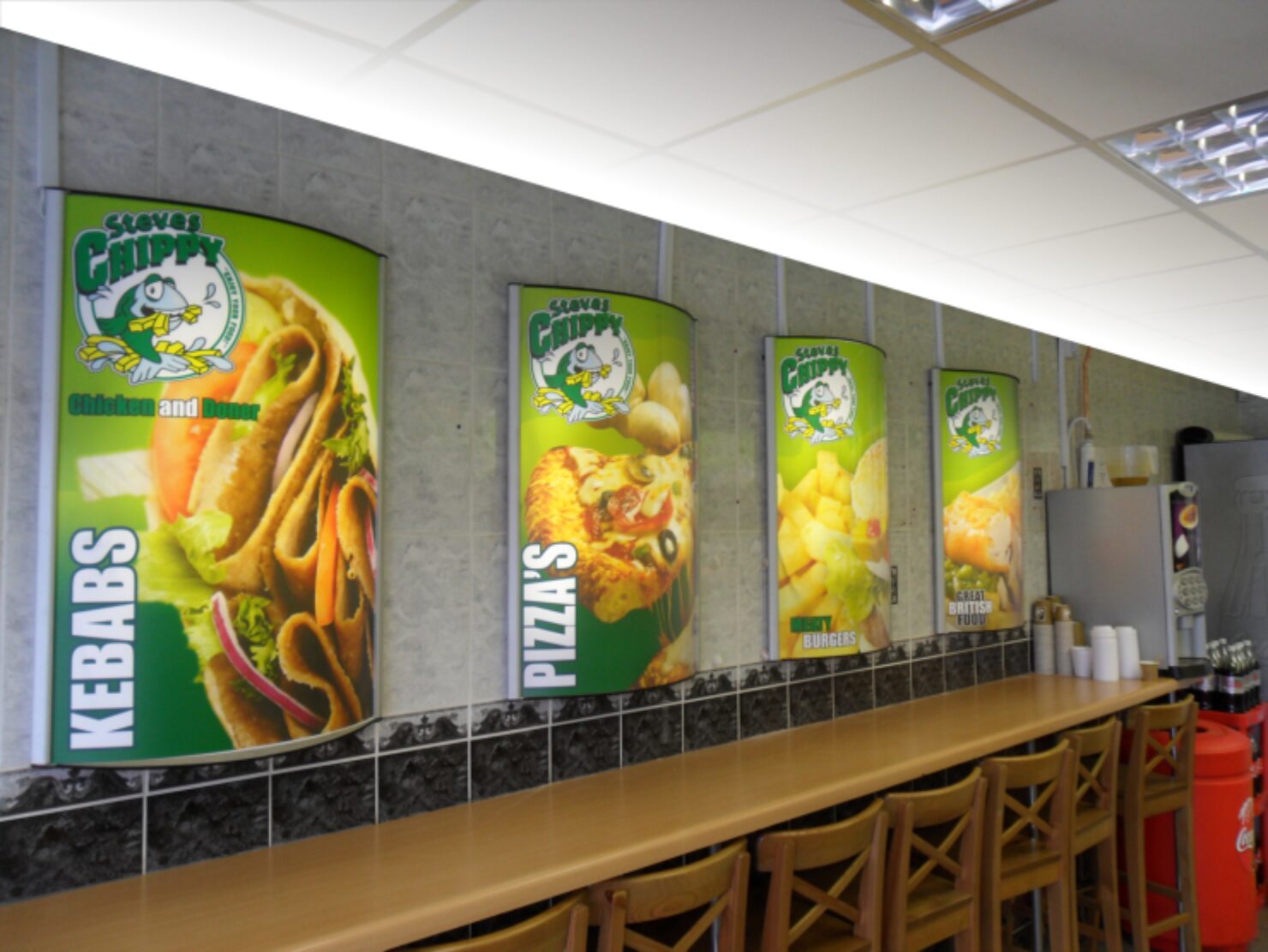 Curved vertical illuminated panels for Steves Chippy showing kebabs, pizzas and burgers