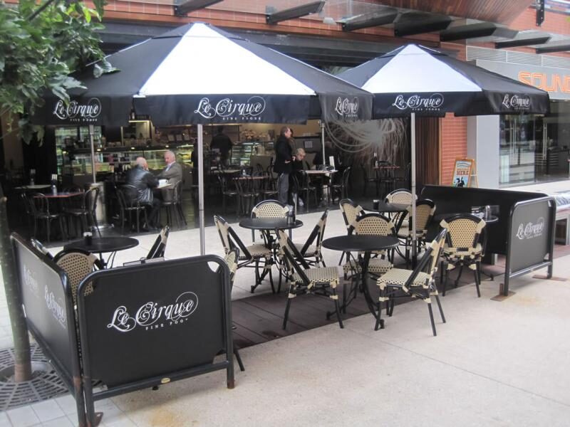 Branded parasols over café tables outside Le Cirque